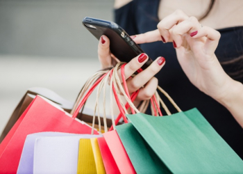 woman with shopping bags holding smartphone 23 2147652180