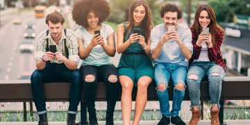 A group of friends surfing the net on a bridge.