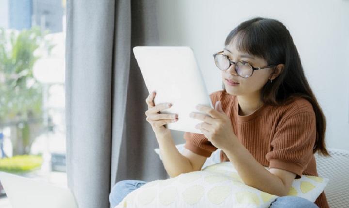 Mujer joven disfrutas las ventajas  de estudiar online 