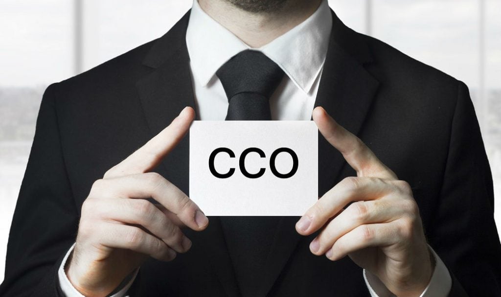 CEO, CIO, CFO, VP: ¿qué significan estas siglas dentro del mundo corporativo? 9 Hombre sostiene un papel con las siglas CCO