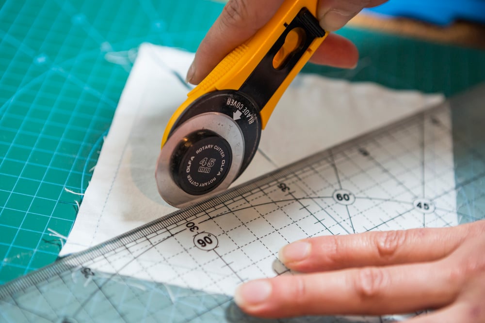 Diseñador usando un cutter para cortar tela