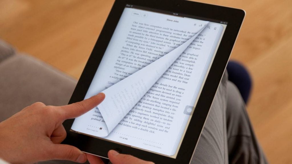 20 libros de diseño gráfico gratis en PDF 2 Persona hojea páginas de sus libros de diseño gráfico PDF