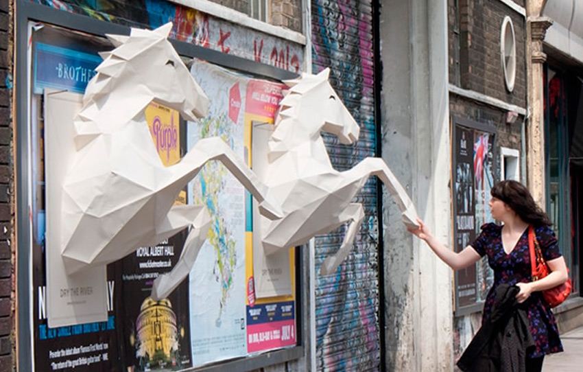 Ejemplo de publicidad exterior OOH. Mujer con anuncios de caballos.