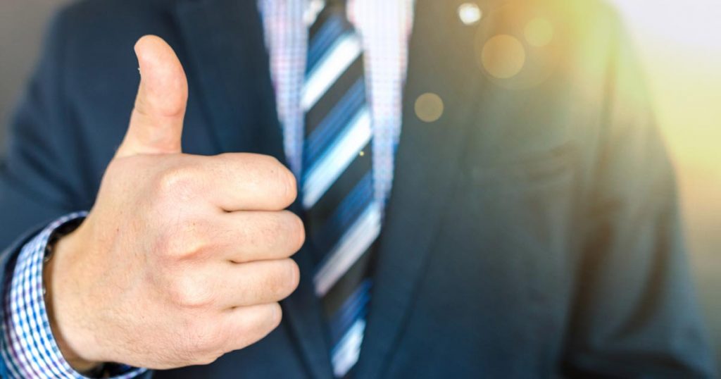 profesional exitosos alza su pulgar tras culminar curso de dirección de ventas