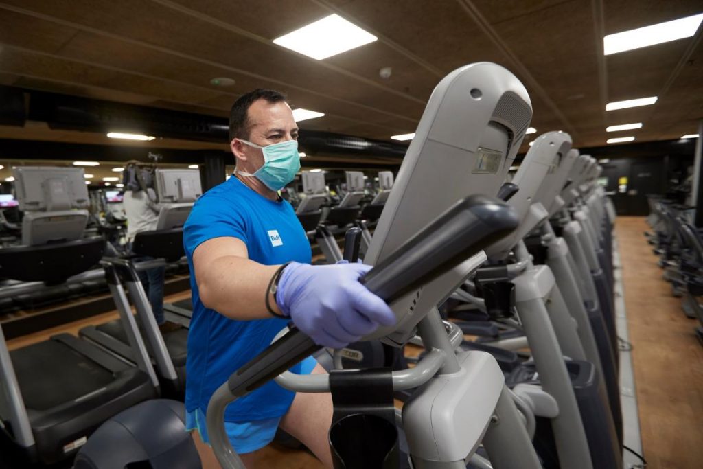 Persona usando máquina trotadora en el gimnasio 