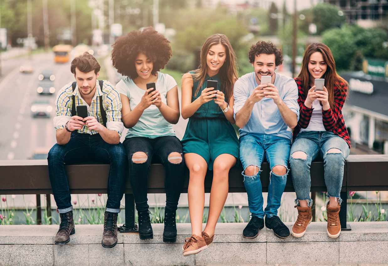¿Un problema para las marcas? Millennials creen que su capacidad de adquisición no mejorará nunca 1 A group of friends surfing the net on a bridge.
