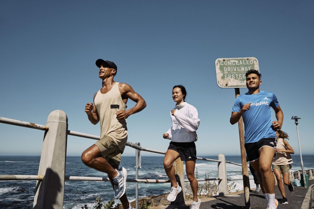 Personas corriendo junto al océano 