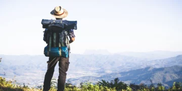 turista cima montana rayos sol hombre usa mochila grande contra luz sol 1150 9121 1