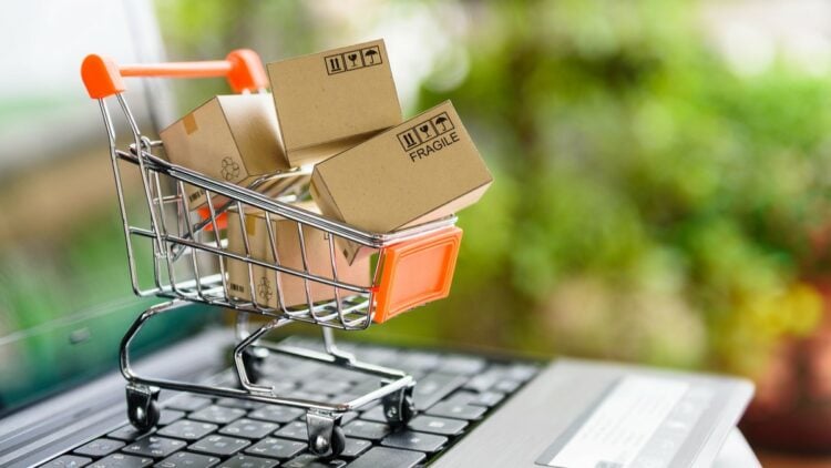 Online shopping and delivery service concept. Paper boxes in a shopping cart on a laptop keyboard, this image implies online shopping that customer order things from retailer sites via the internet.