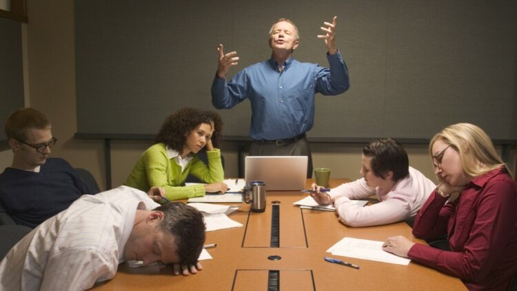 Businessman speaking before inattentive colleagues at meeting