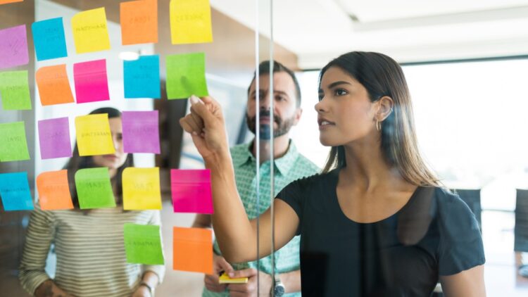 Colleagues Planning Over Adhesives With Team In Workplace