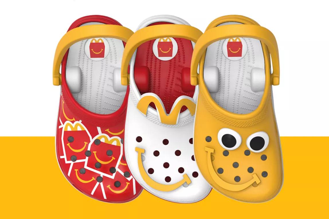 McDonald's lanza una Cajita Feliz de Crocs con 12 mini llaveros coleccionables 4 Three Crocs-themed toy clogs in red, white and yellow displayed side by side.