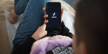 TikTok prepara una función para realizar transferencias de dinero mediante su plataforma 2 Nizhny Novgorod, Russia October 03 2020: child with phone in his hands is lying at home on bed. Social Media tiktok is loaded on screen.