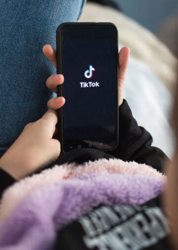 MercadoNegro 30 Nizhny Novgorod, Russia October 03 2020: child with phone in his hands is lying at home on bed. Social Media tiktok is loaded on screen.